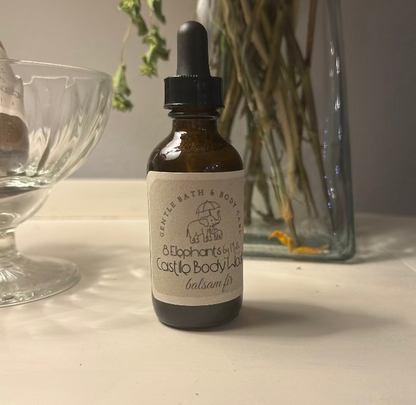 Bottle of Castile body wash with dropper on a surface with decorative items in the background