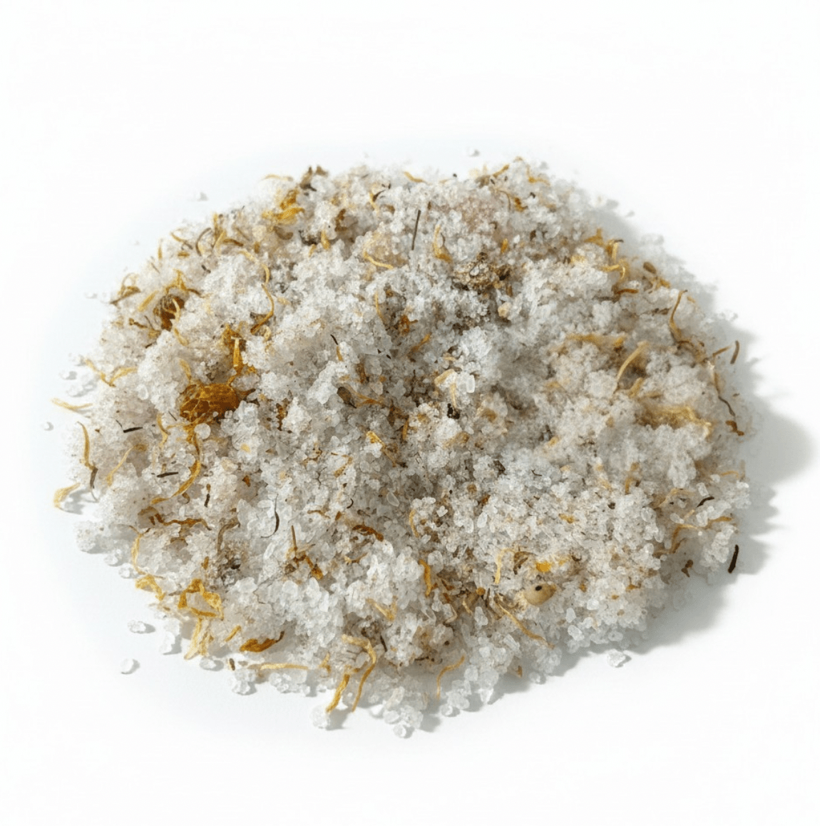 A mound of coarse white salt crystals mixed with dried yellow and brown herbal or botanical flecks, photographed on a clean white background.