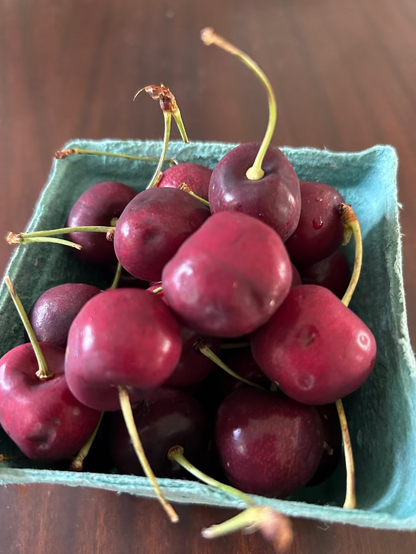 Box of cherries on a wooden surface